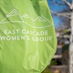 Green flag outside with East Cascade Women's Group logo in white on the flag