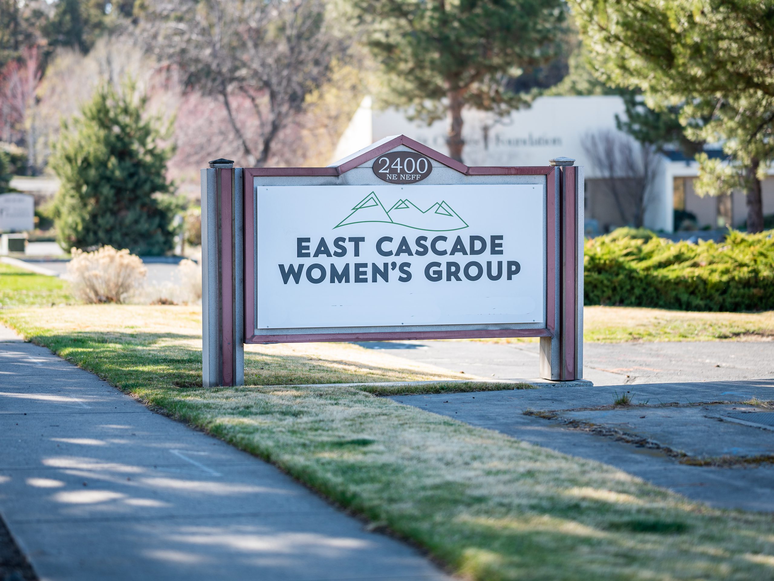 Outdoor sign for clinic with East Cascade Women's Group surrounded by grass and trees