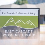 Sign in front of clinic building with the text 'East Cascade Professional Building' followed by East Cascade Women's Group Logo